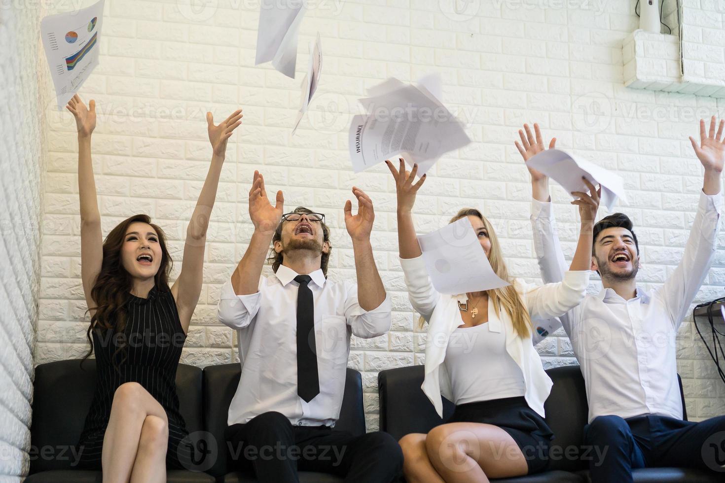 Happy business people throwing documents in the air photo