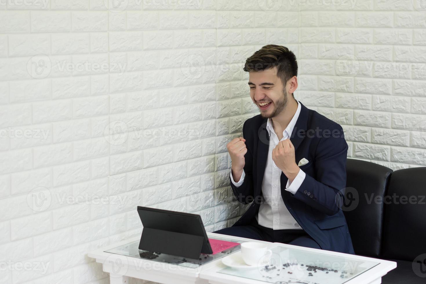 Successful young businessman working on laptop at office photo