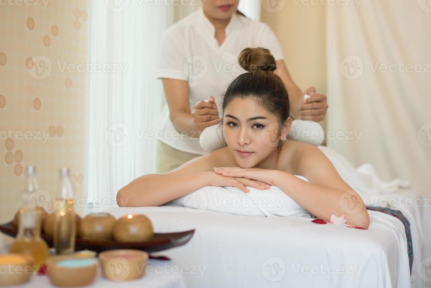 Mujer hermosa joven con masaje saludable en un salón de spa foto