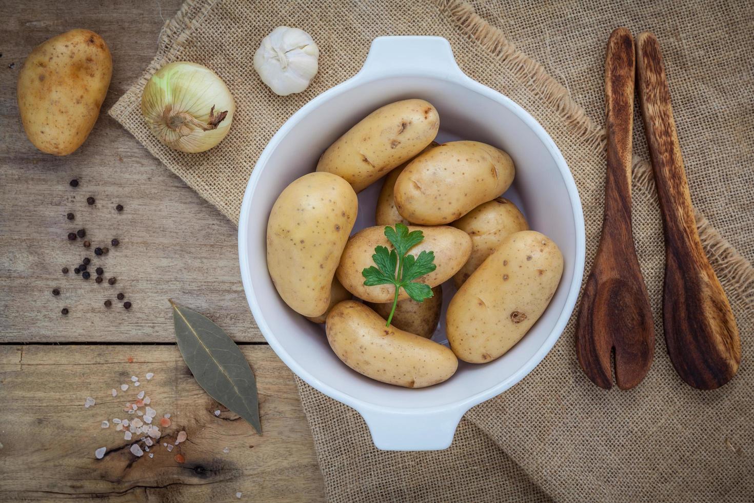 Fresh potatoes on wood photo