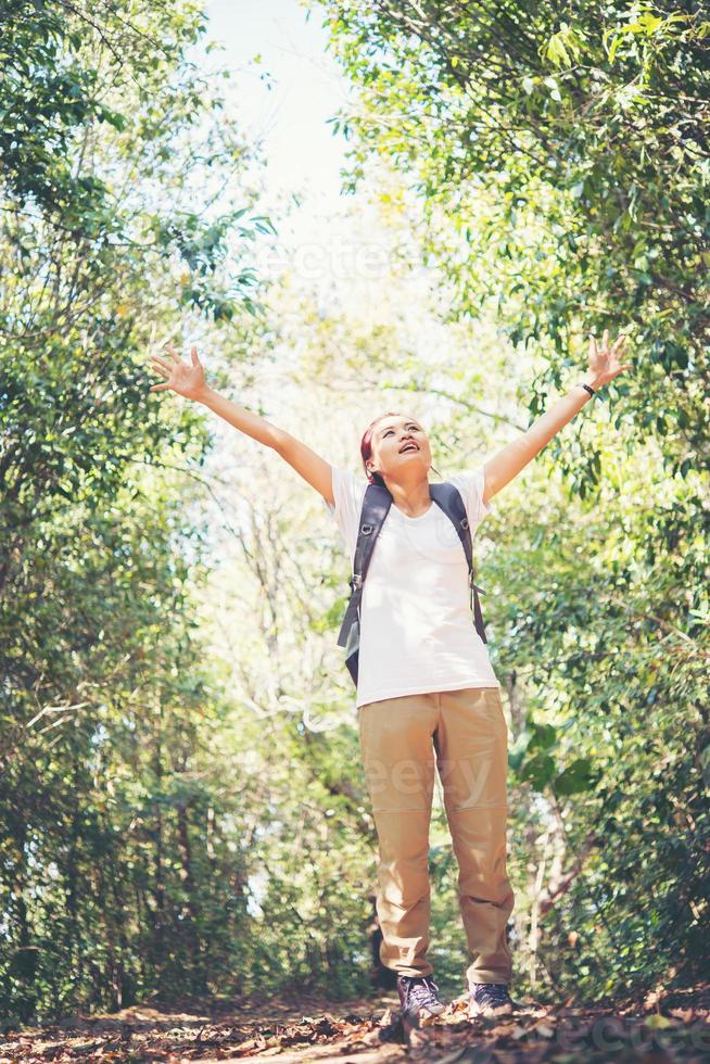 Attractive woman hiker with open arms at mountain while hiking photo