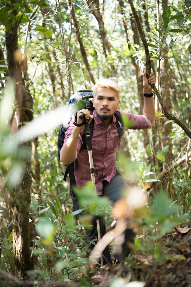 Active young man hiker though the forest to the mountain photo