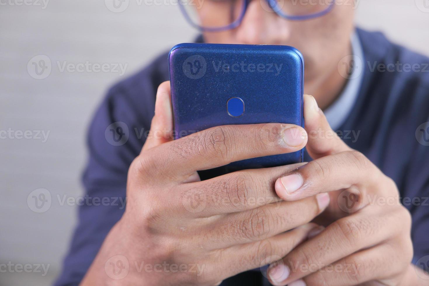 Close up of young man's hand using smart phone photo