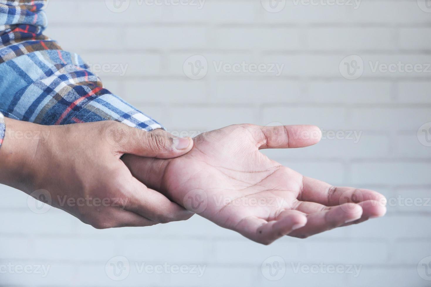 hombre agarrando la muñeca con dolor foto