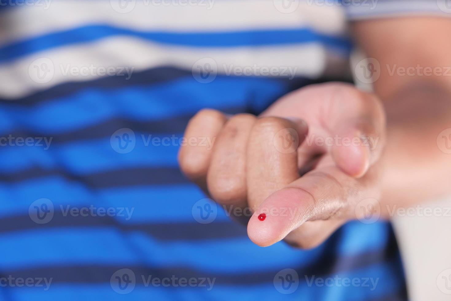 pequeña gota de sangre en un dedo foto