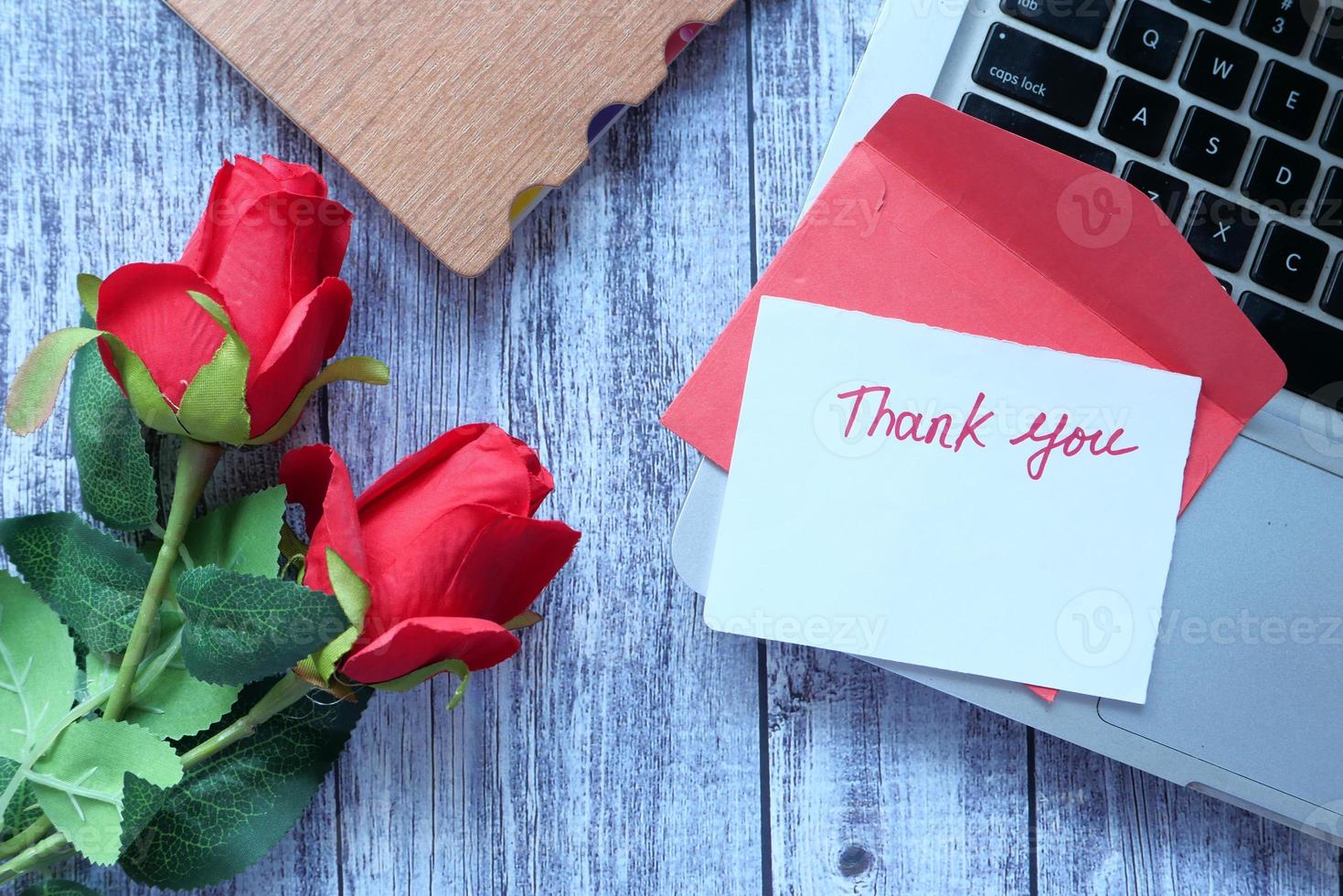 Thank you message and envelope on wooden table photo