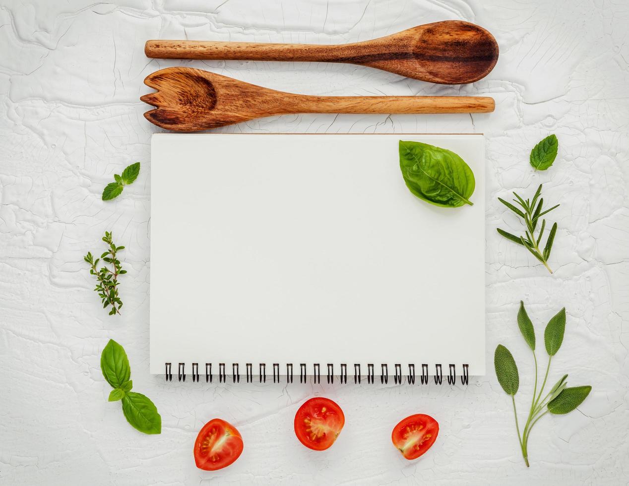 Spiral notebook with fresh herbs and tomatoes photo