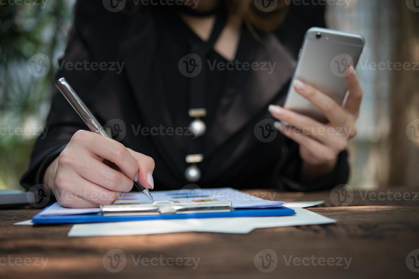 Mujer de negocios feliz firmando un documento en un escritorio trabajando en casa foto