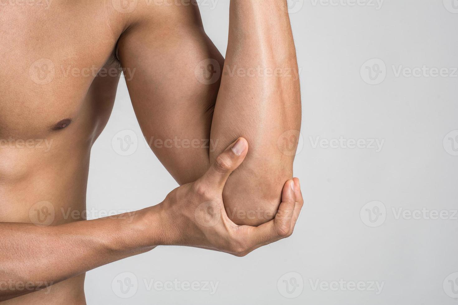 Retrato de un hombre musculoso con dolor en el codo aislado sobre fondo blanco. foto