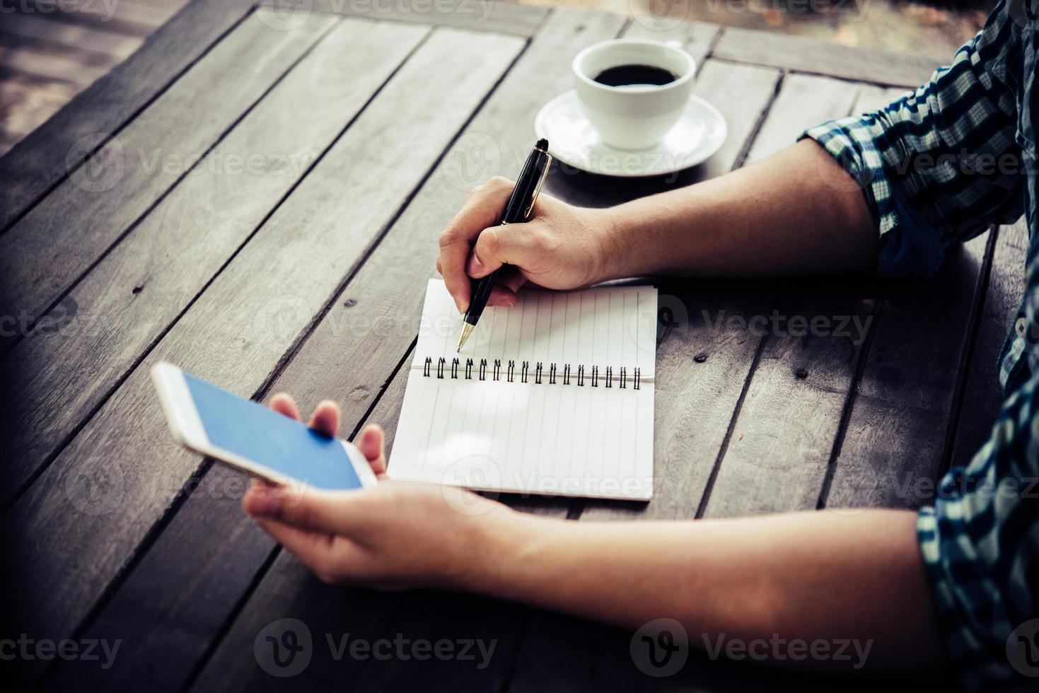 Close-up of businessman using smartphone while working in the cafe photo