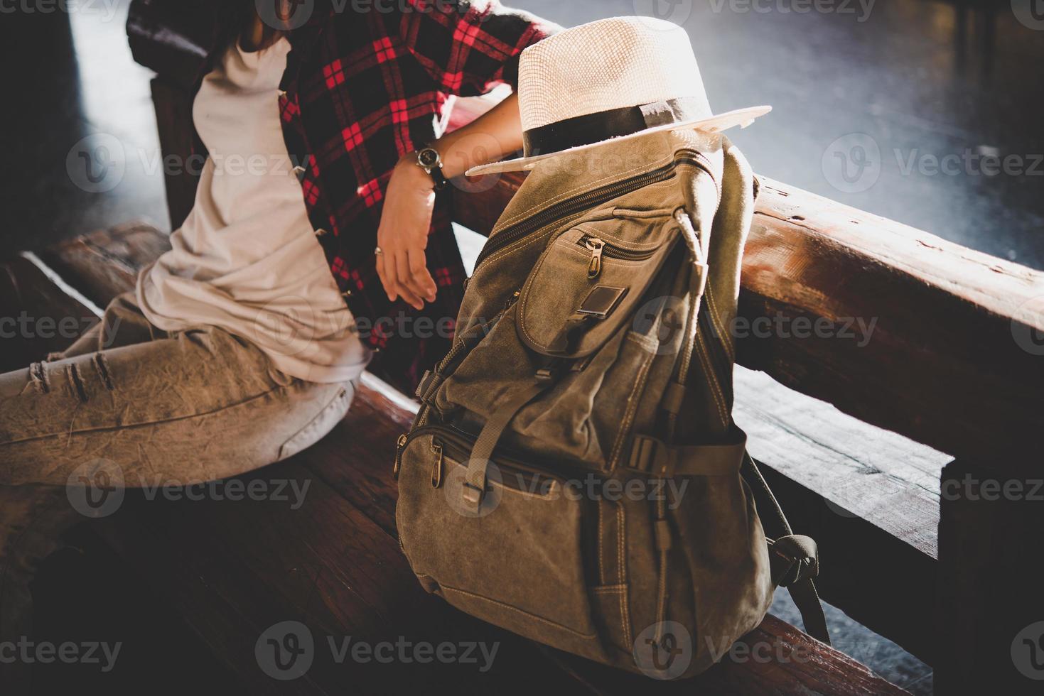 Mujer joven turista hipster con mochila sentado en la estación de tren foto