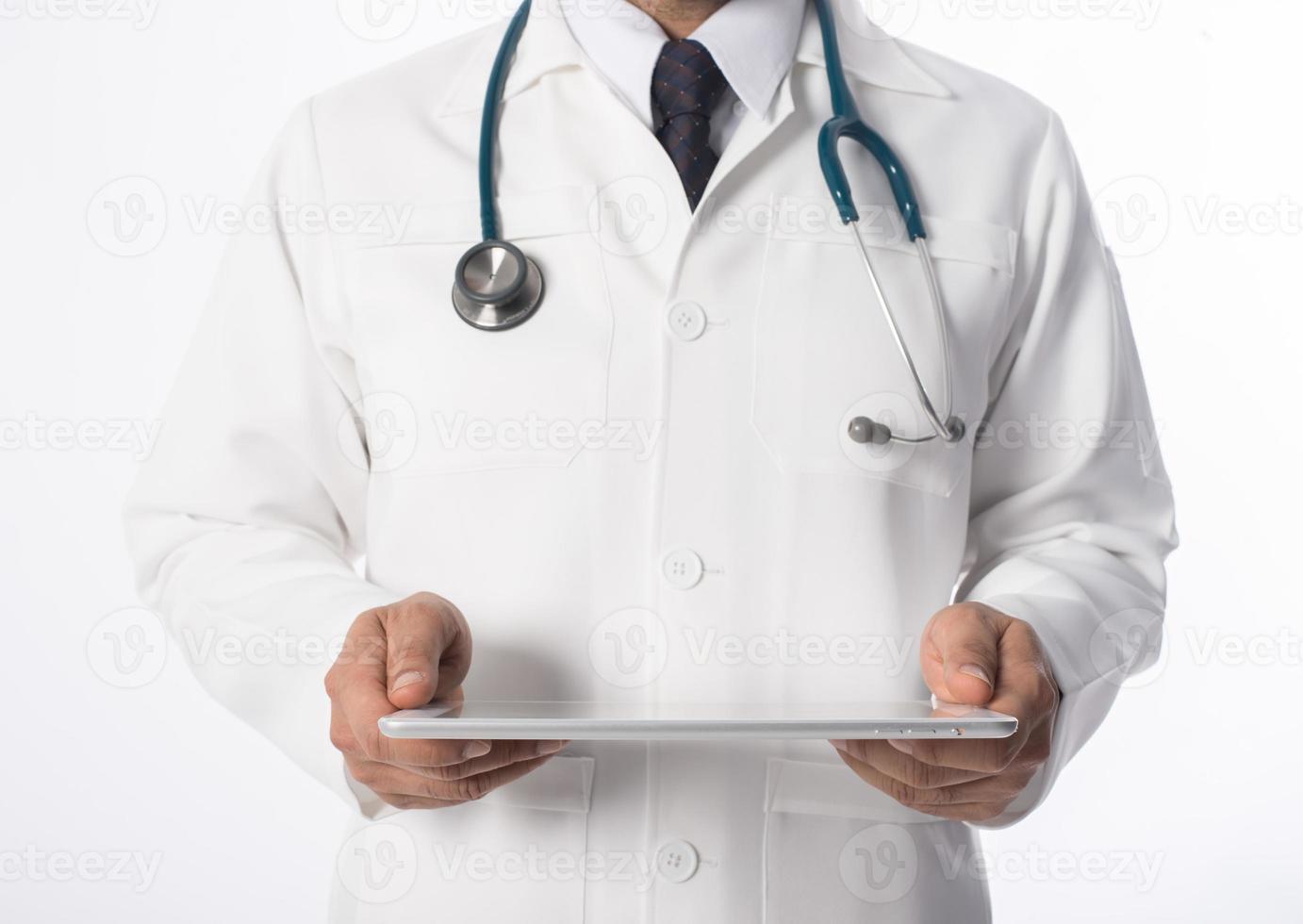 Young medical doctor holding a tablet pc isolated on gray background photo