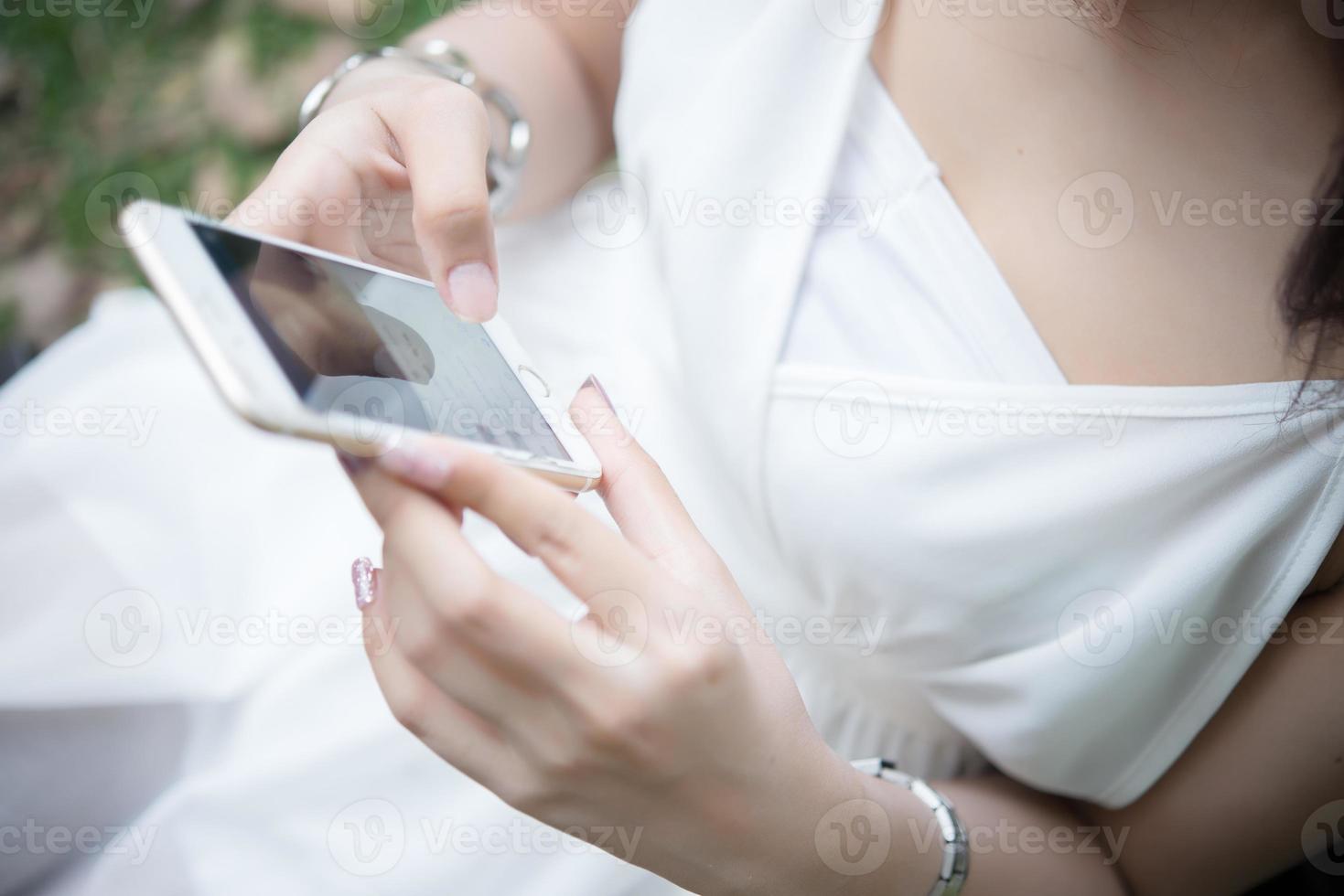 niña sentada con smartphone en manos foto