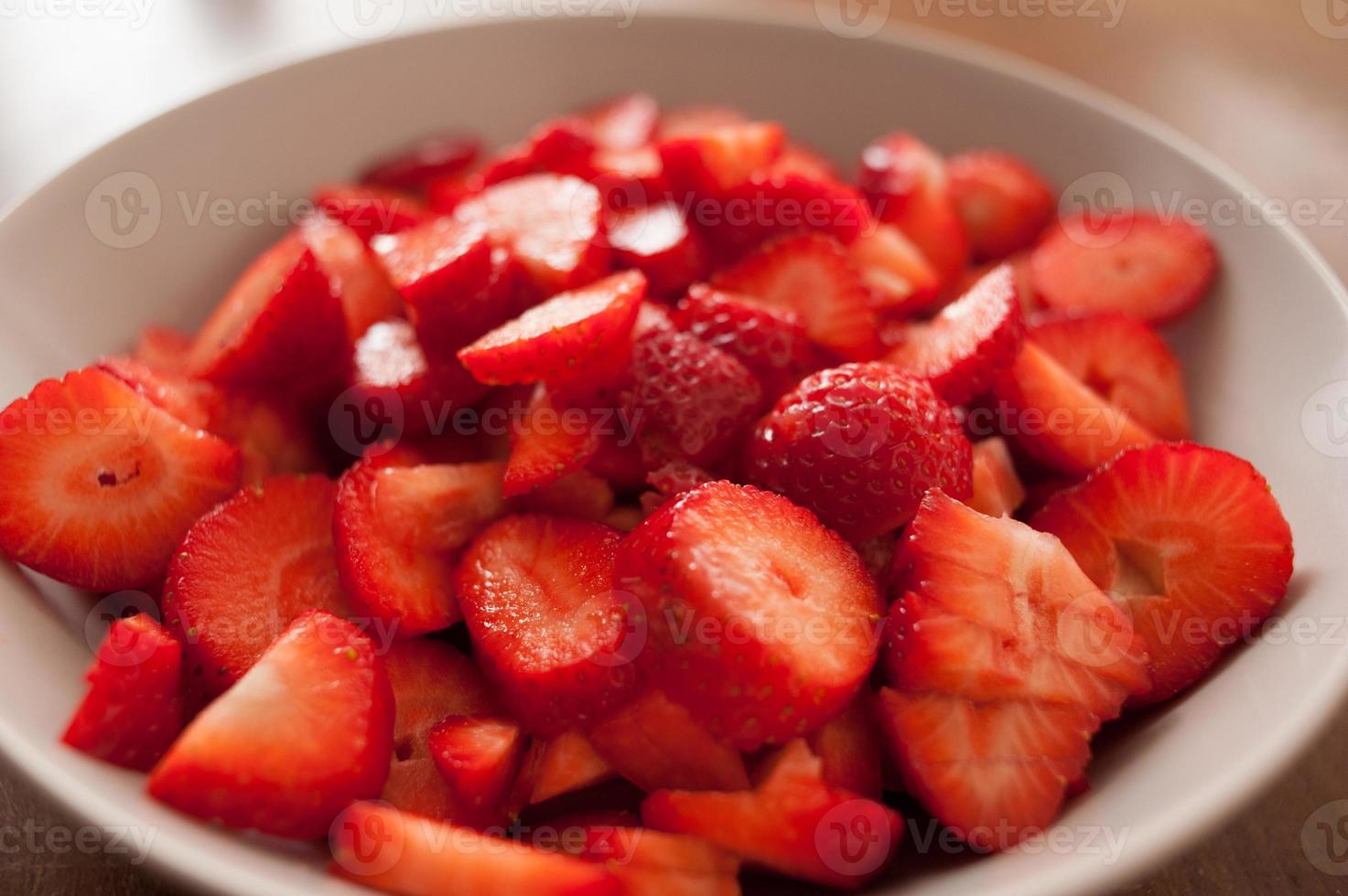 Close-up de fresas en rodajas sobre una placa blanca. foto