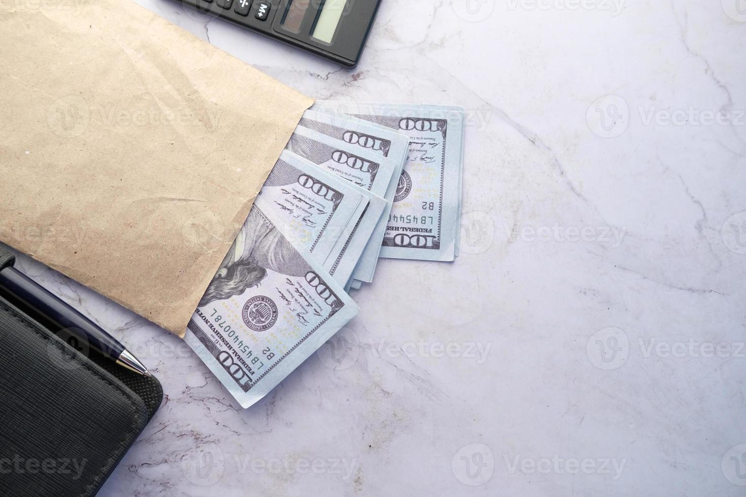 Vista superior de efectivo y monedas en un sobre en la mesa foto
