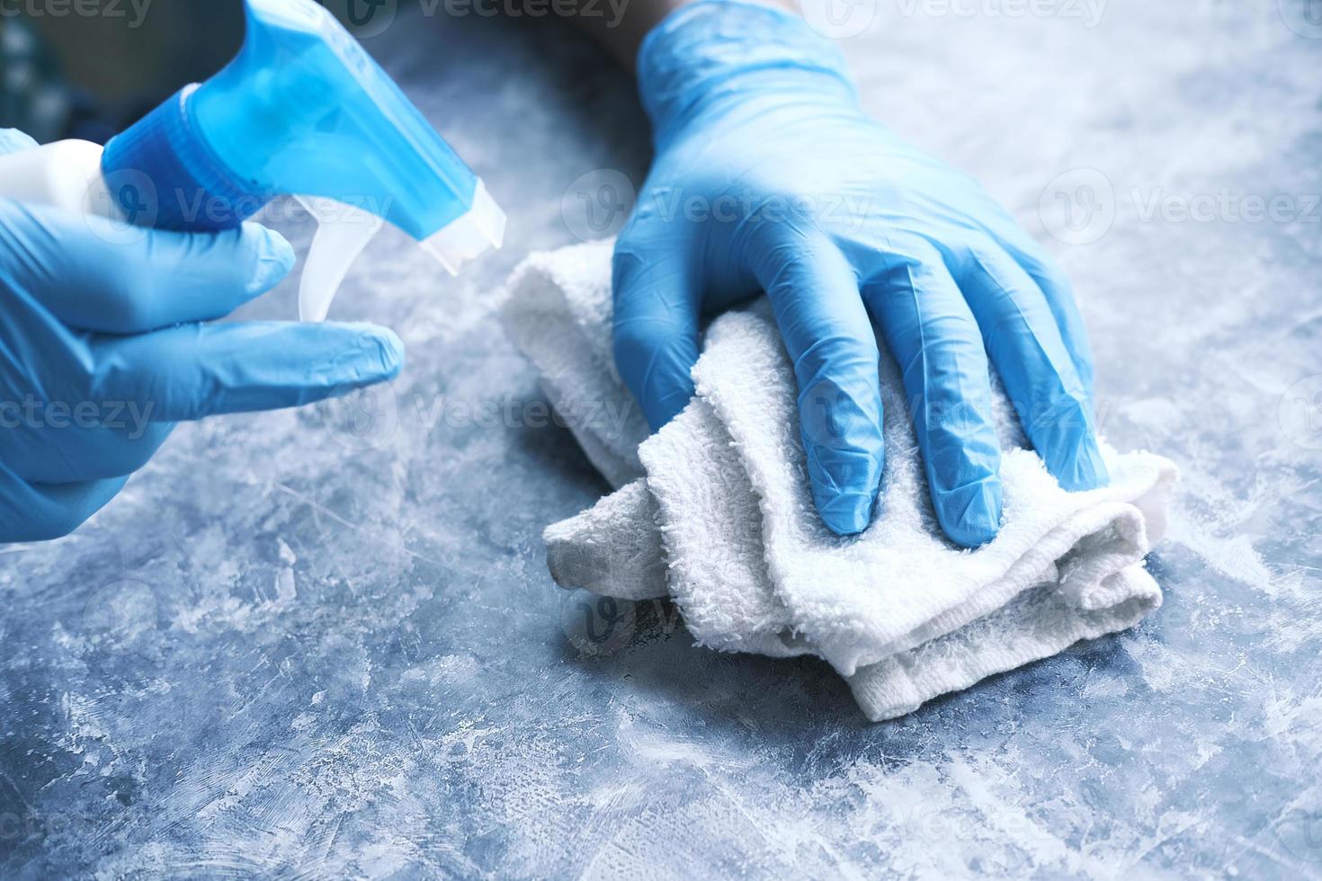 Hands disinfecting a surface photo