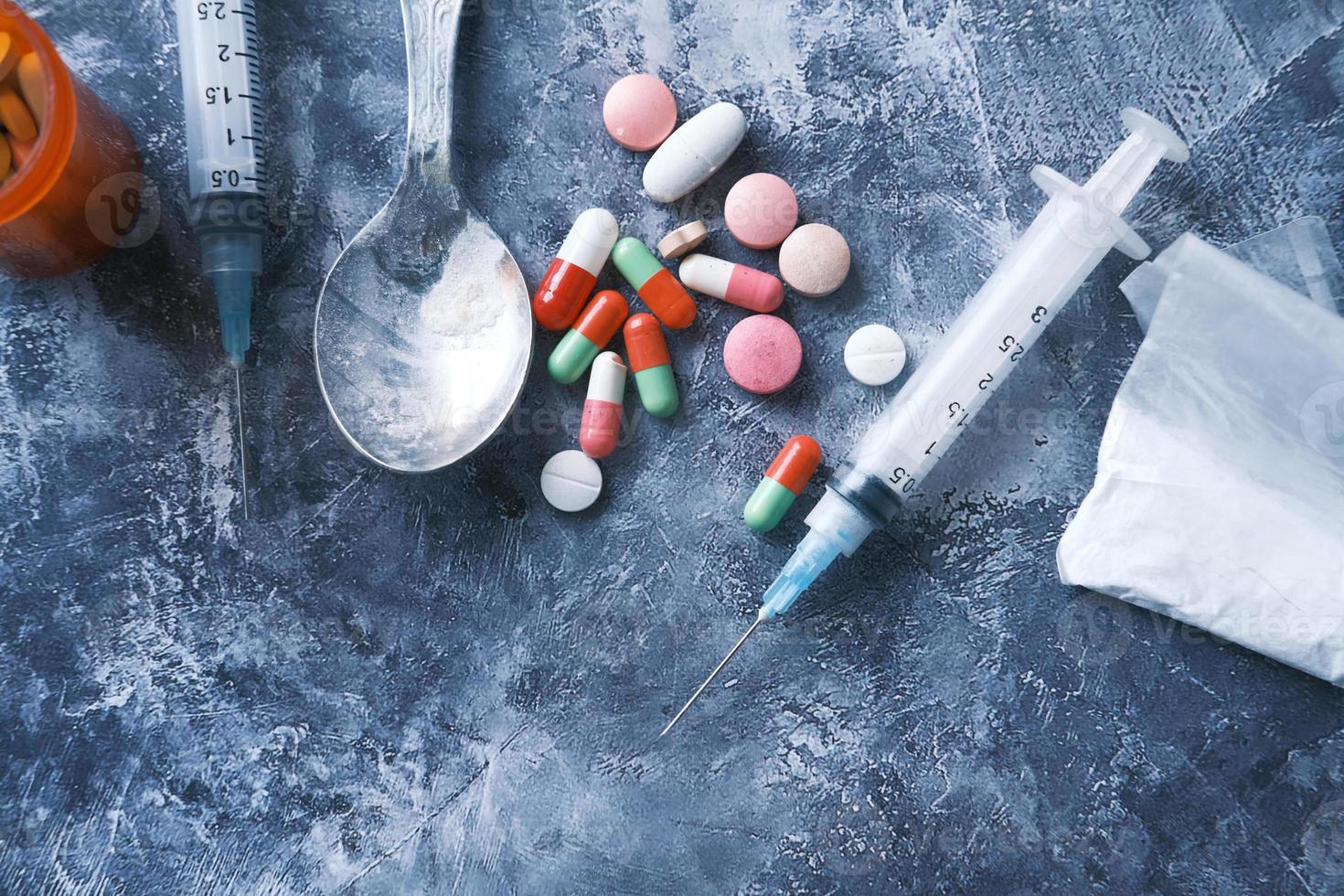 Syringe and pills on a dark background photo