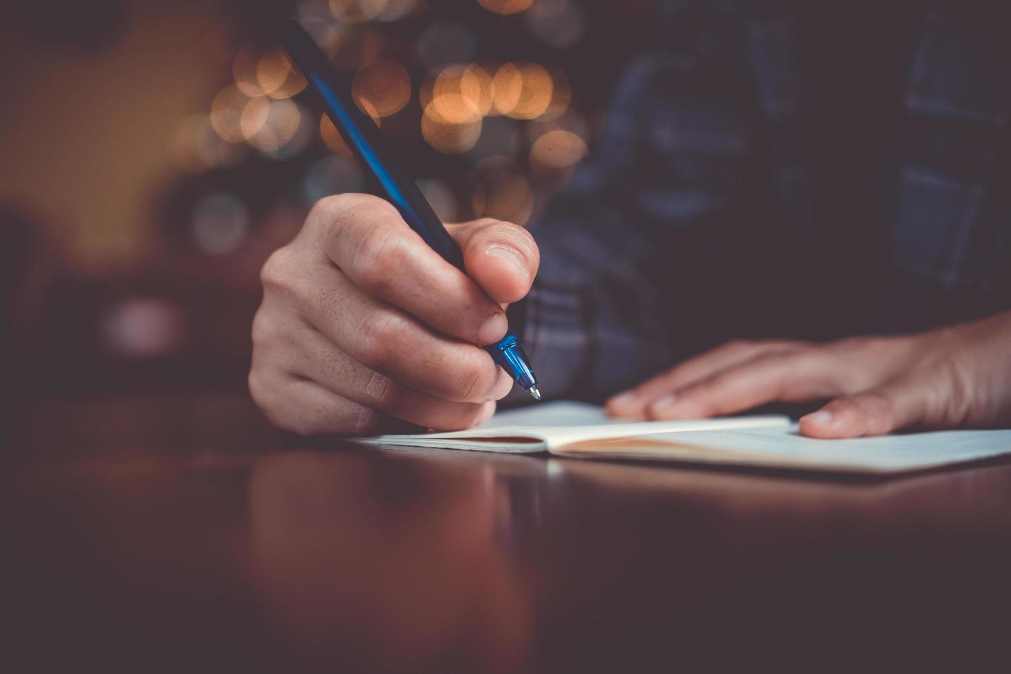 Woman hand writing in small memo notebook photo