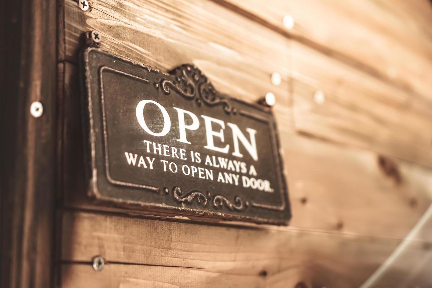 A business sign that says open on door at entrance photo