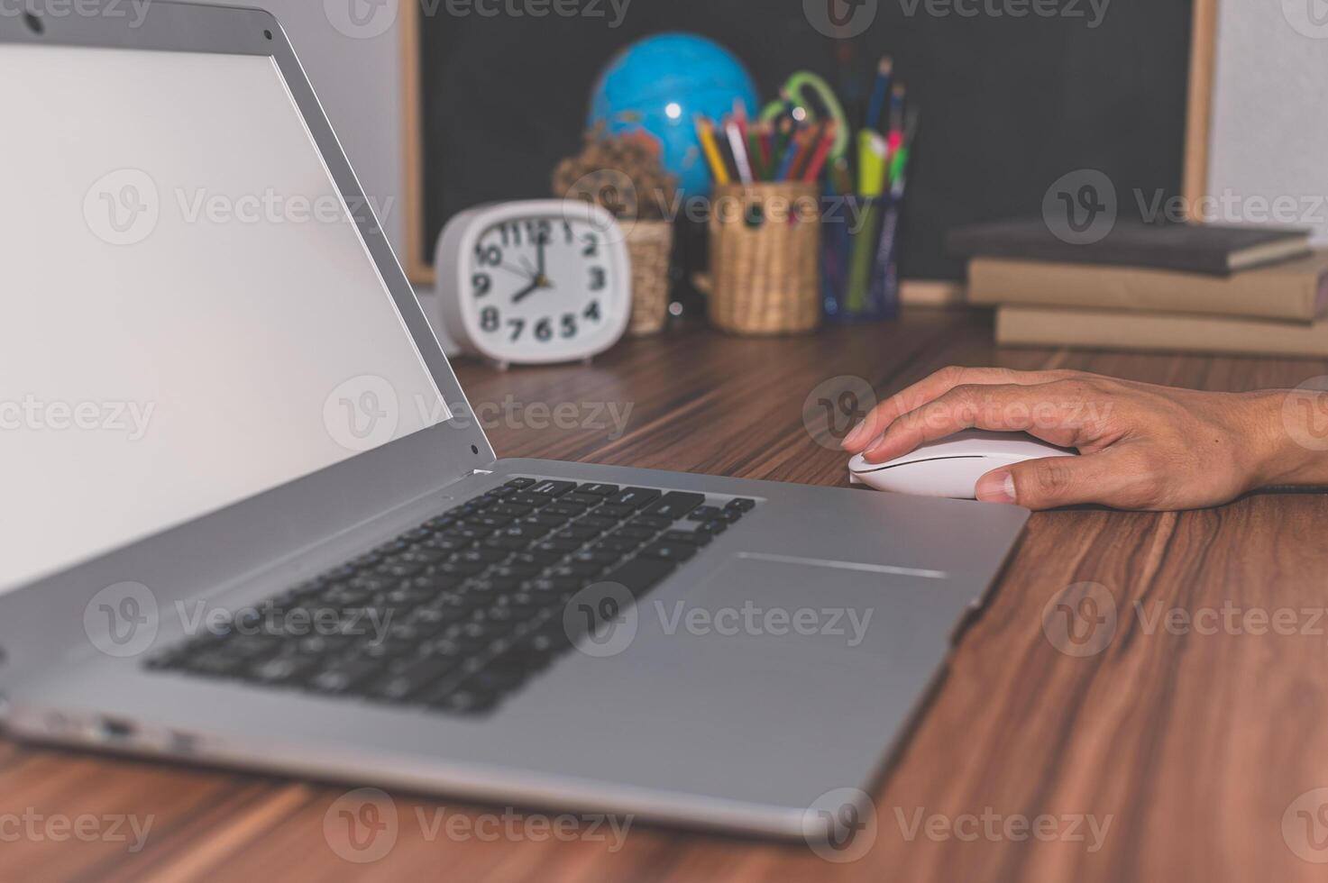 A person using a mouse on a laptop photo