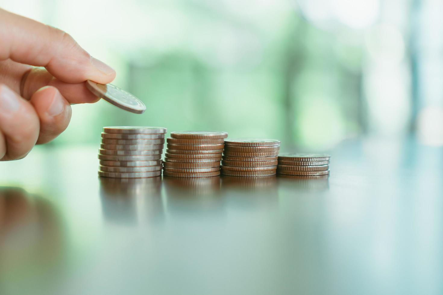 Gold coins on table and green nature bokeh background photo