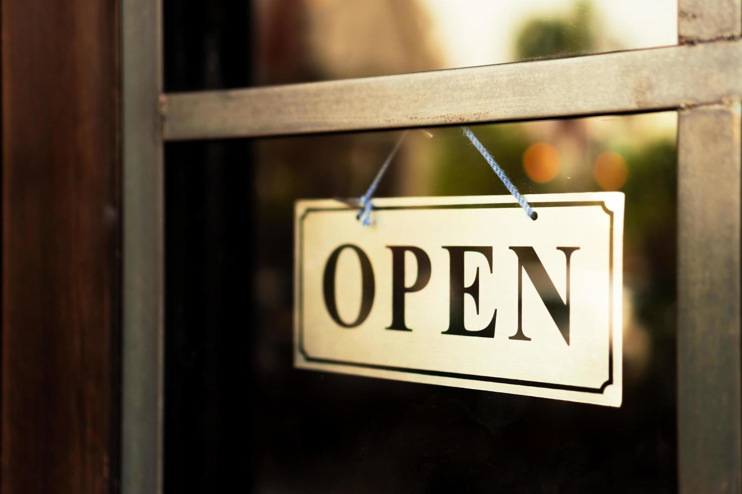 A business sign that says open on door at entrance photo