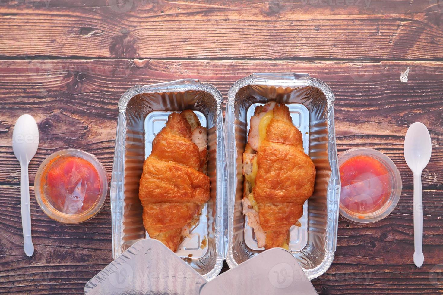 Two croissant sandwiches in takeout containers photo