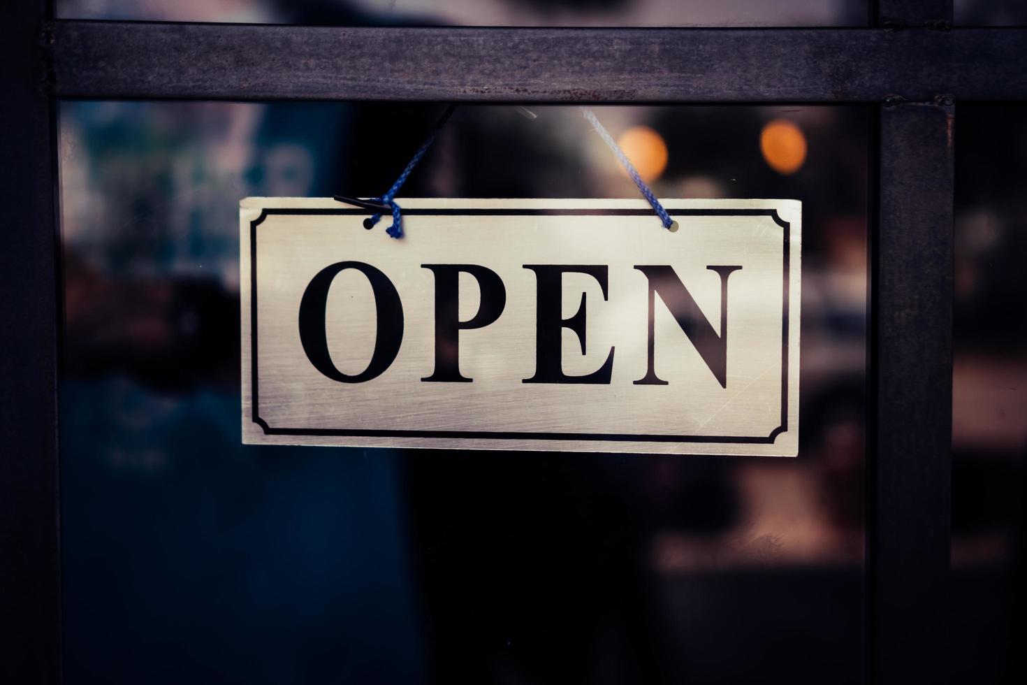 un letrero comercial que dice abrir en la puerta en la entrada foto