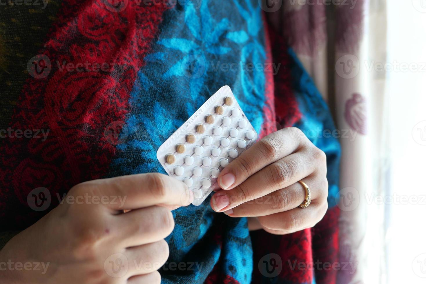 Woman holding birth control pills photo