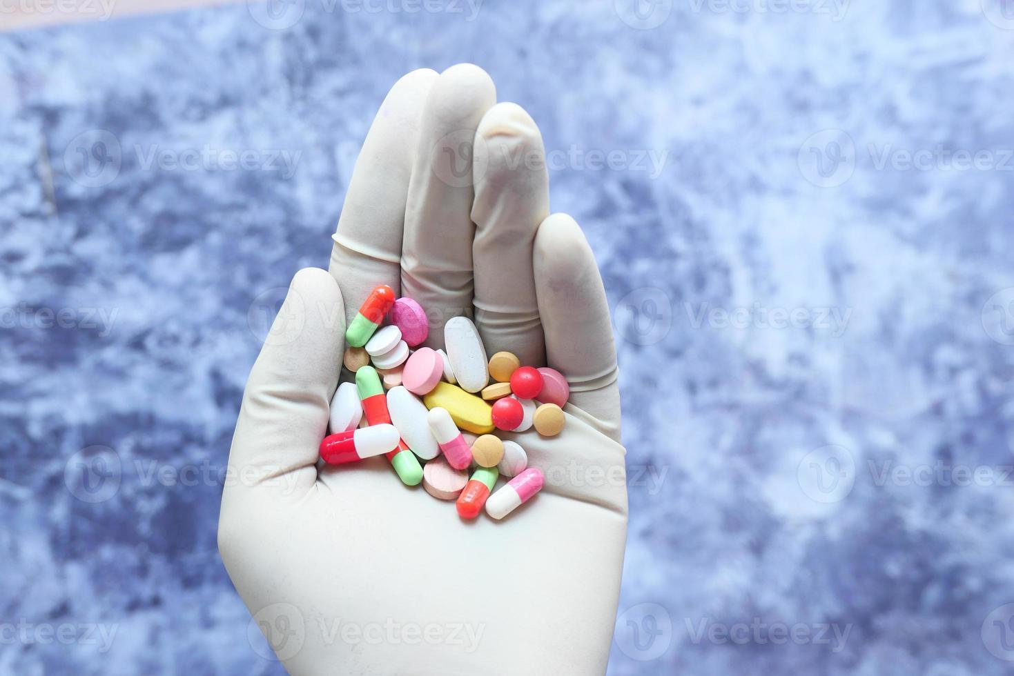 Hand holding a bunch of colorful pills photo