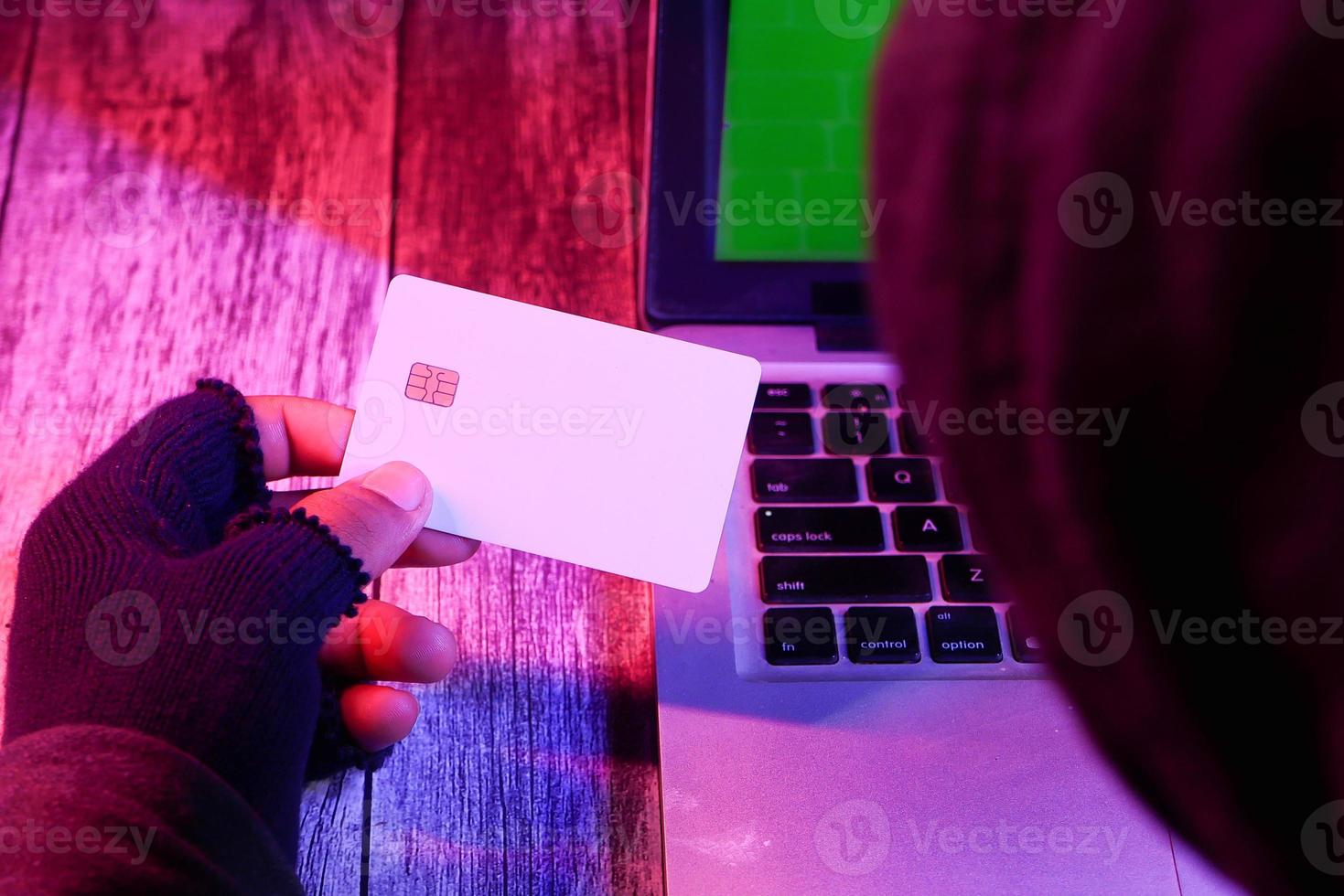 mano del hacker una tarjeta de crédito foto
