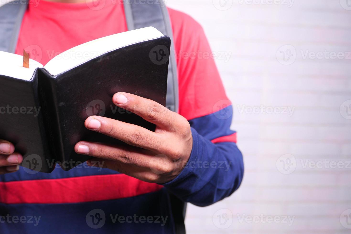 Man reading a black book photo