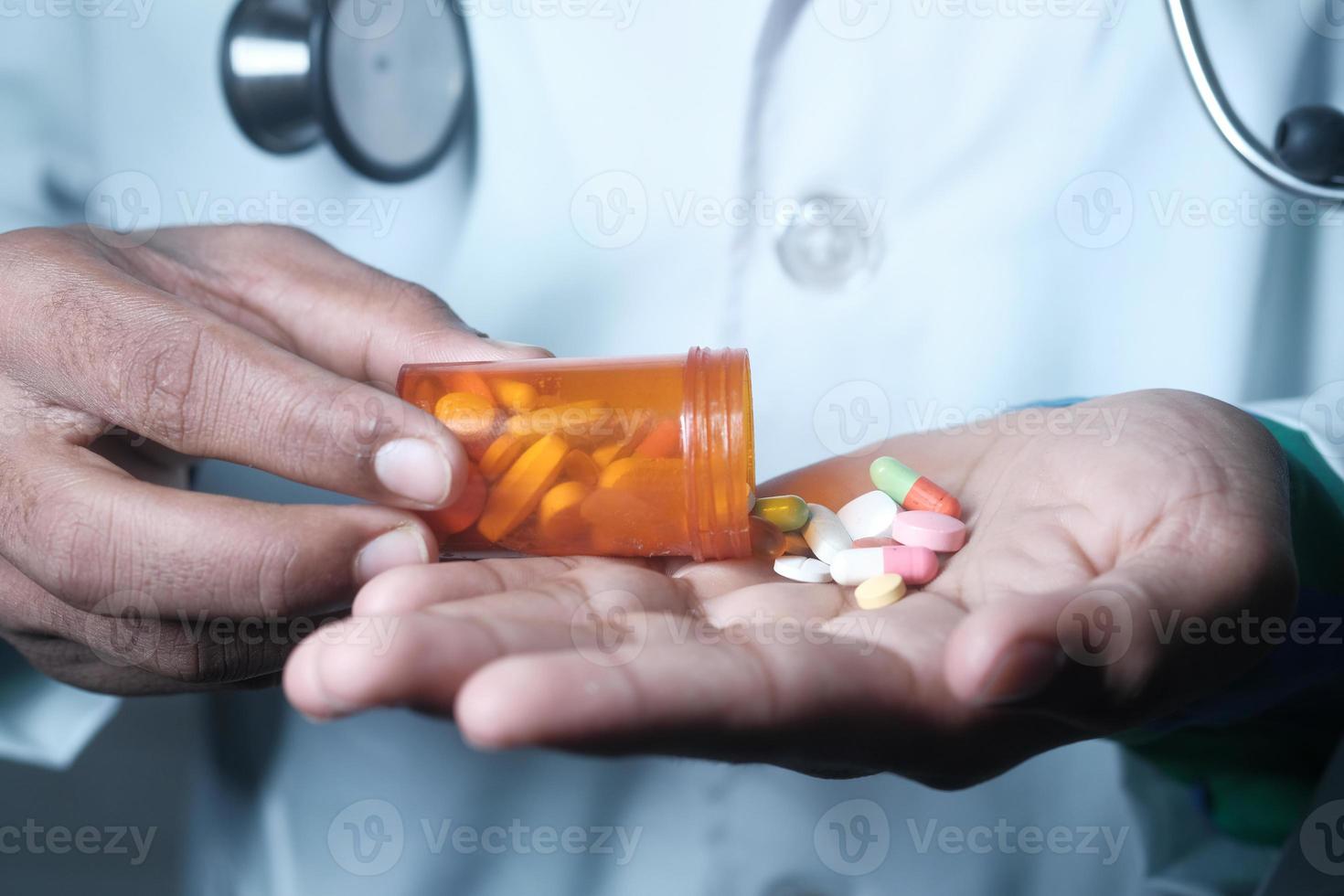 Doctor's hand holding pill container photo