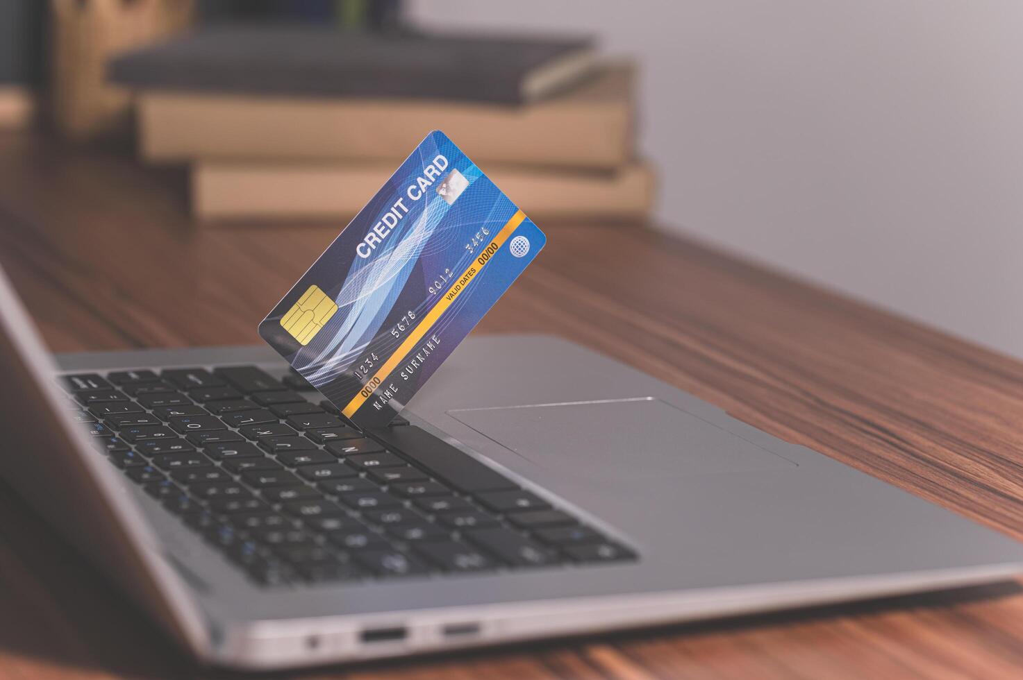 People use credit cards to shop online through computers photo