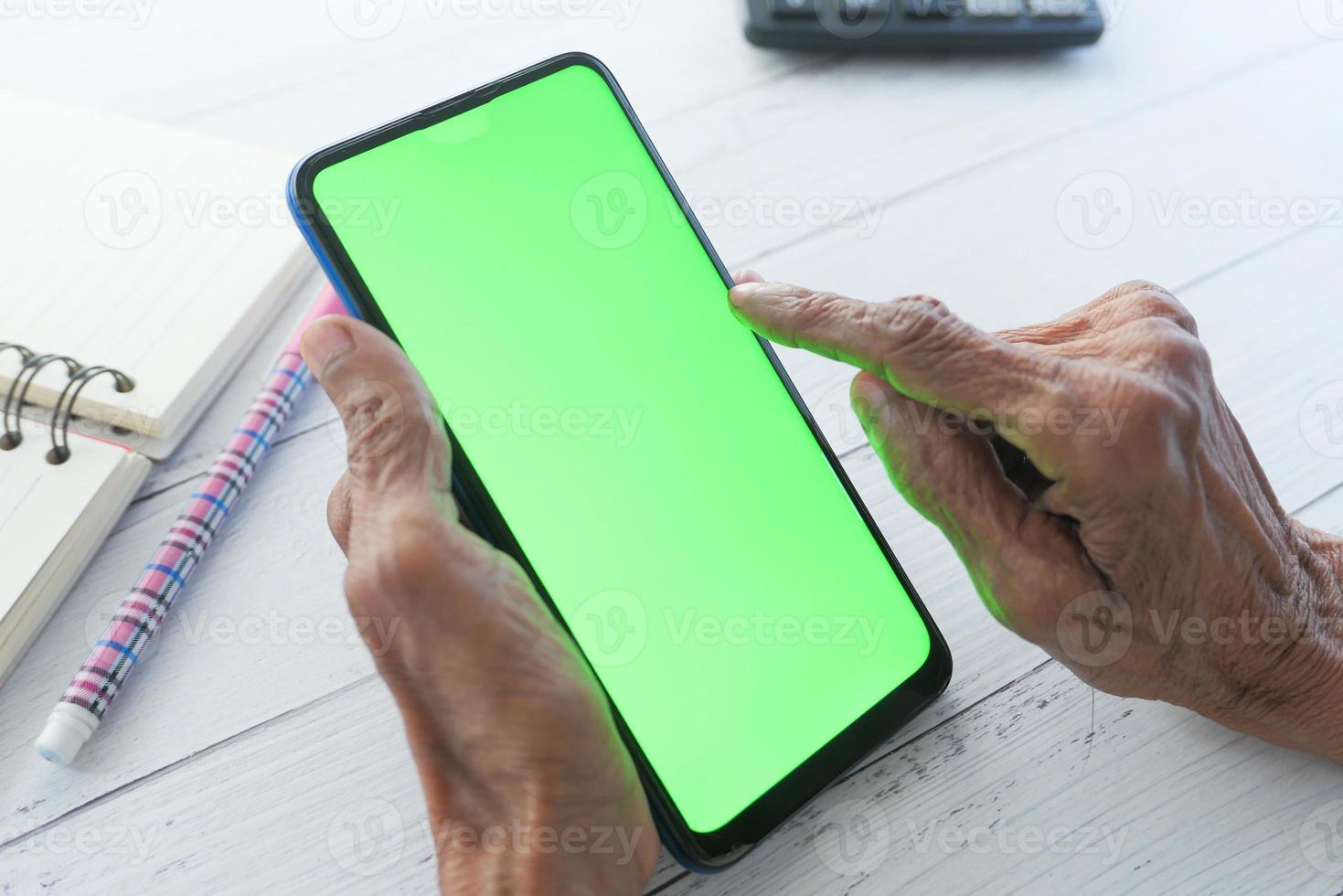 mano de mujer mayor con teléfono inteligente foto