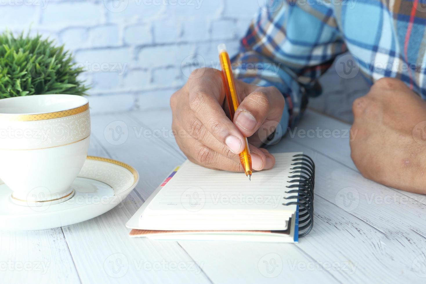 hombre escribiendo en un cuaderno foto