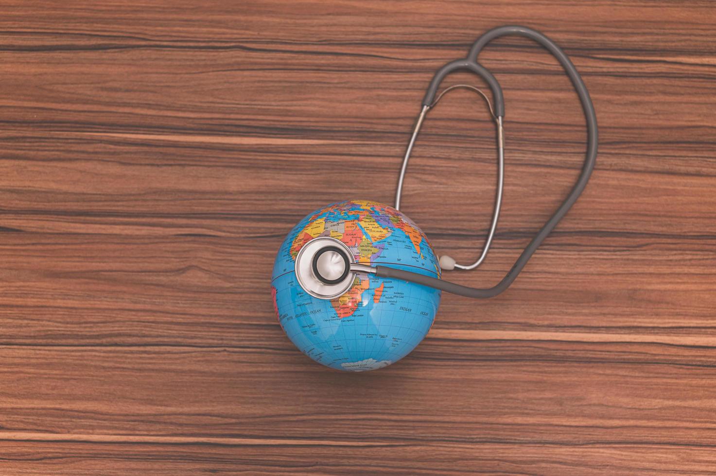 el concepto de salvar el mundo, pequeño globo con estetoscopio foto