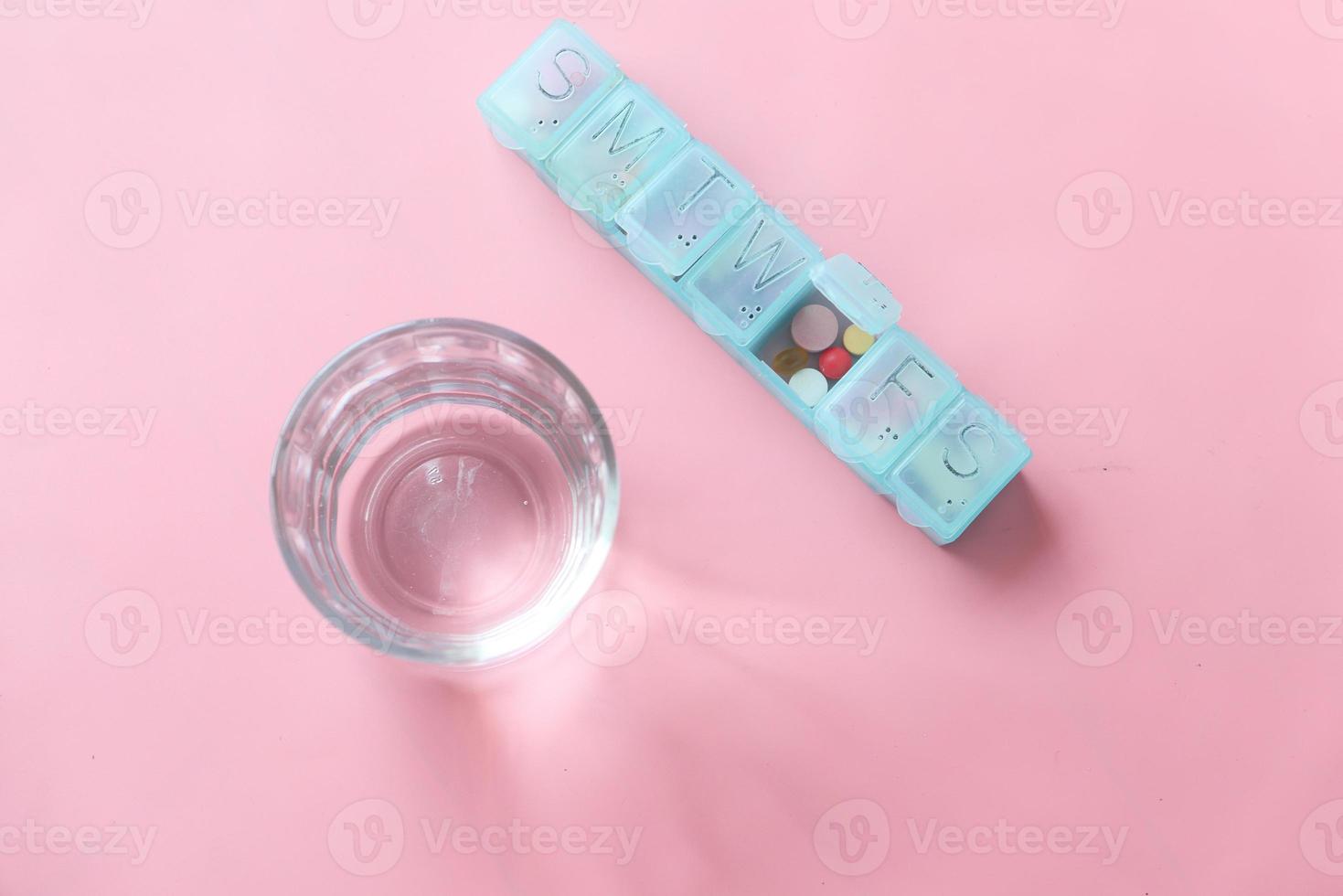 pastillero sobre fondo rosa foto