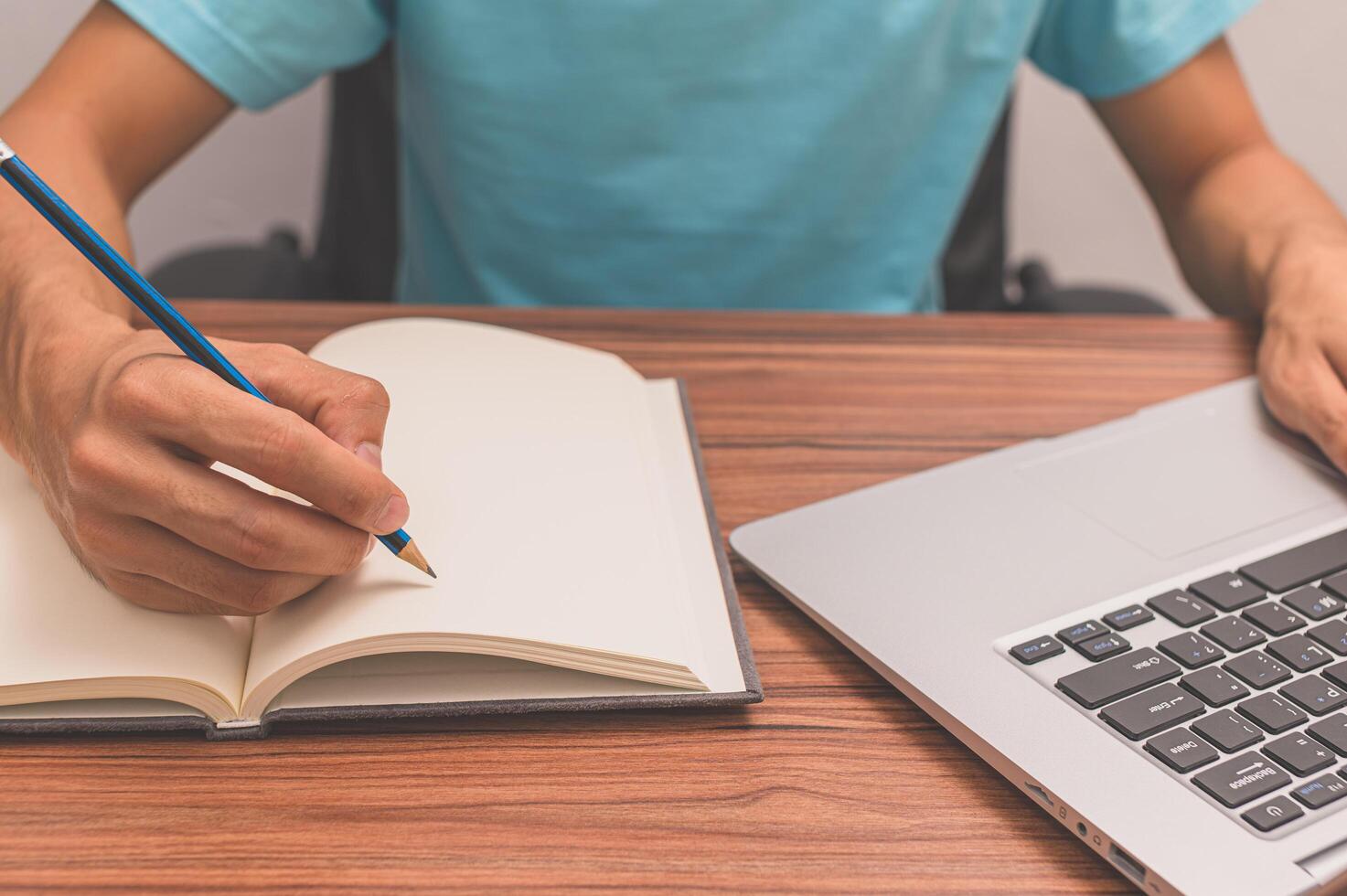 Person writing a book at a desk photo