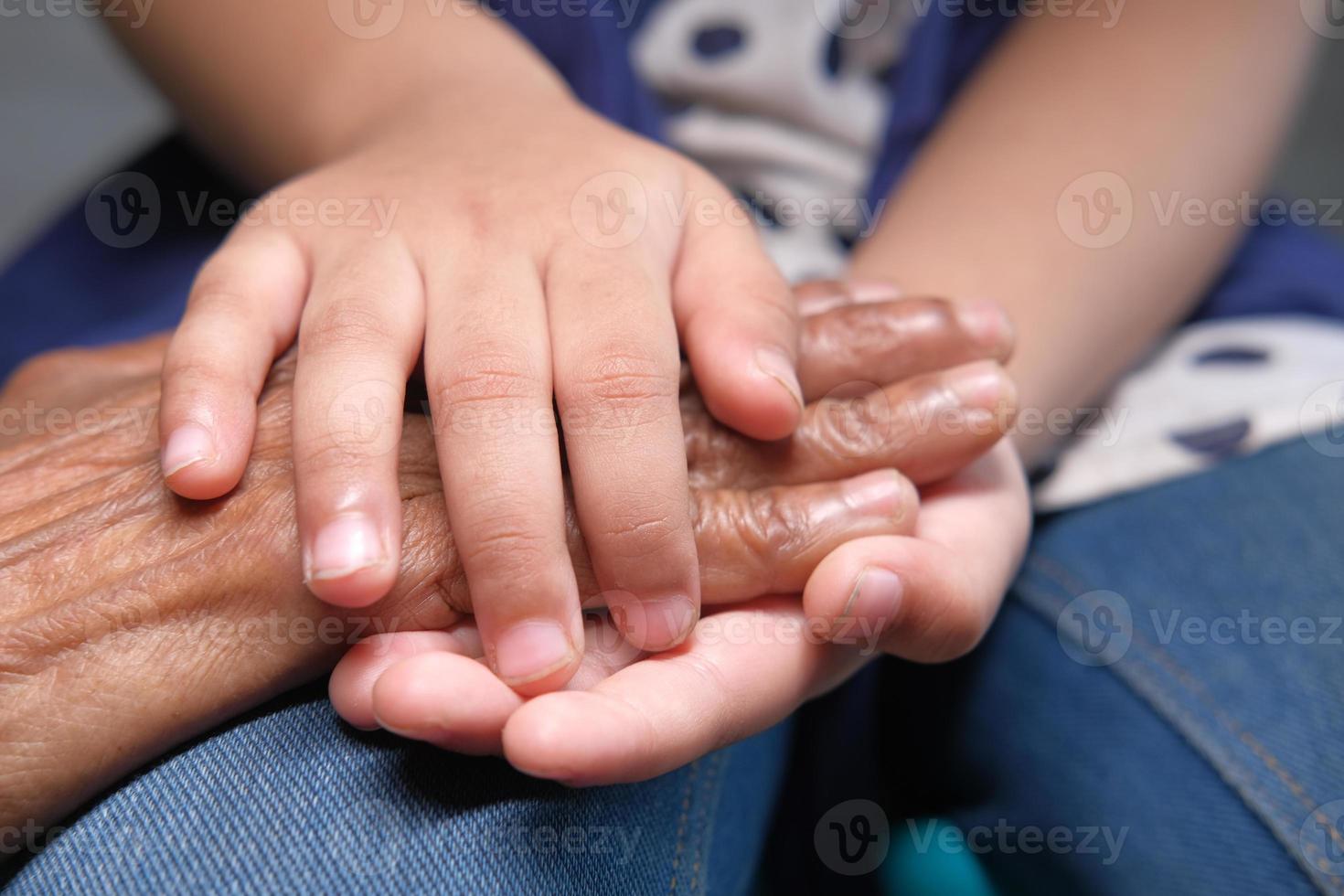 mano de niño sosteniendo la mano de una mujer mayor foto