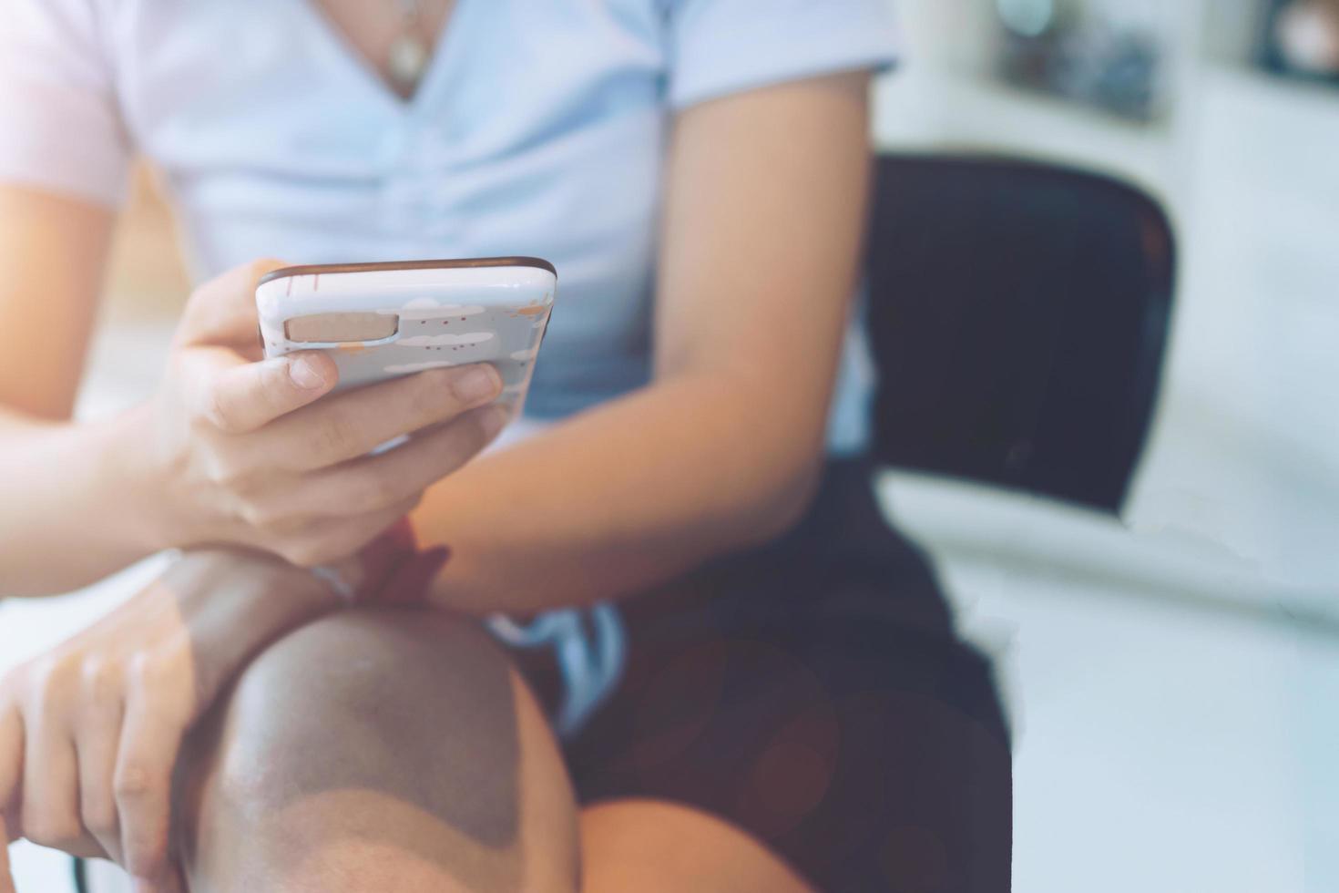 Woman using a smartphone at cafe shop with sunlight photo