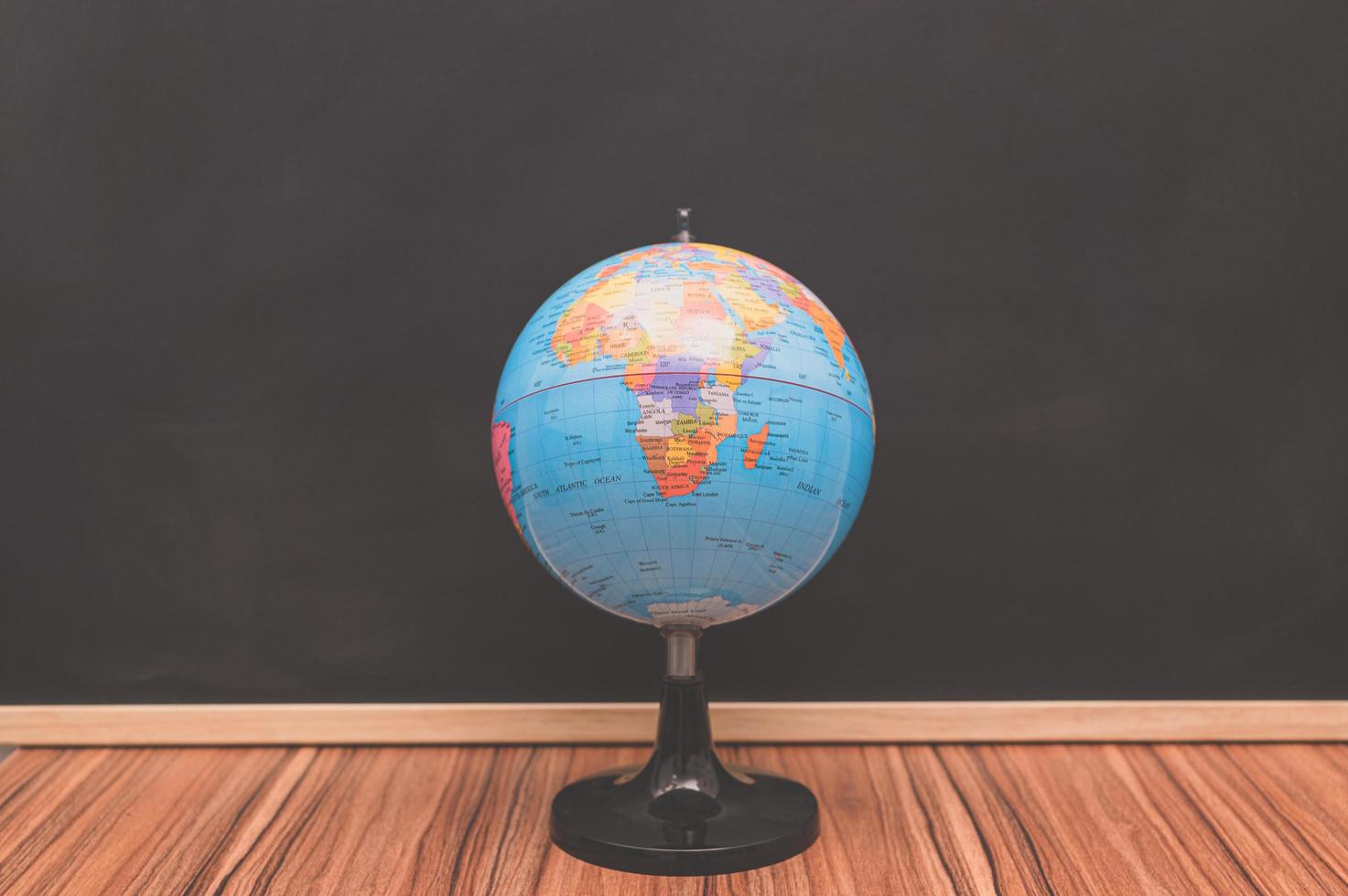 Small world globe on chalkboard background photo