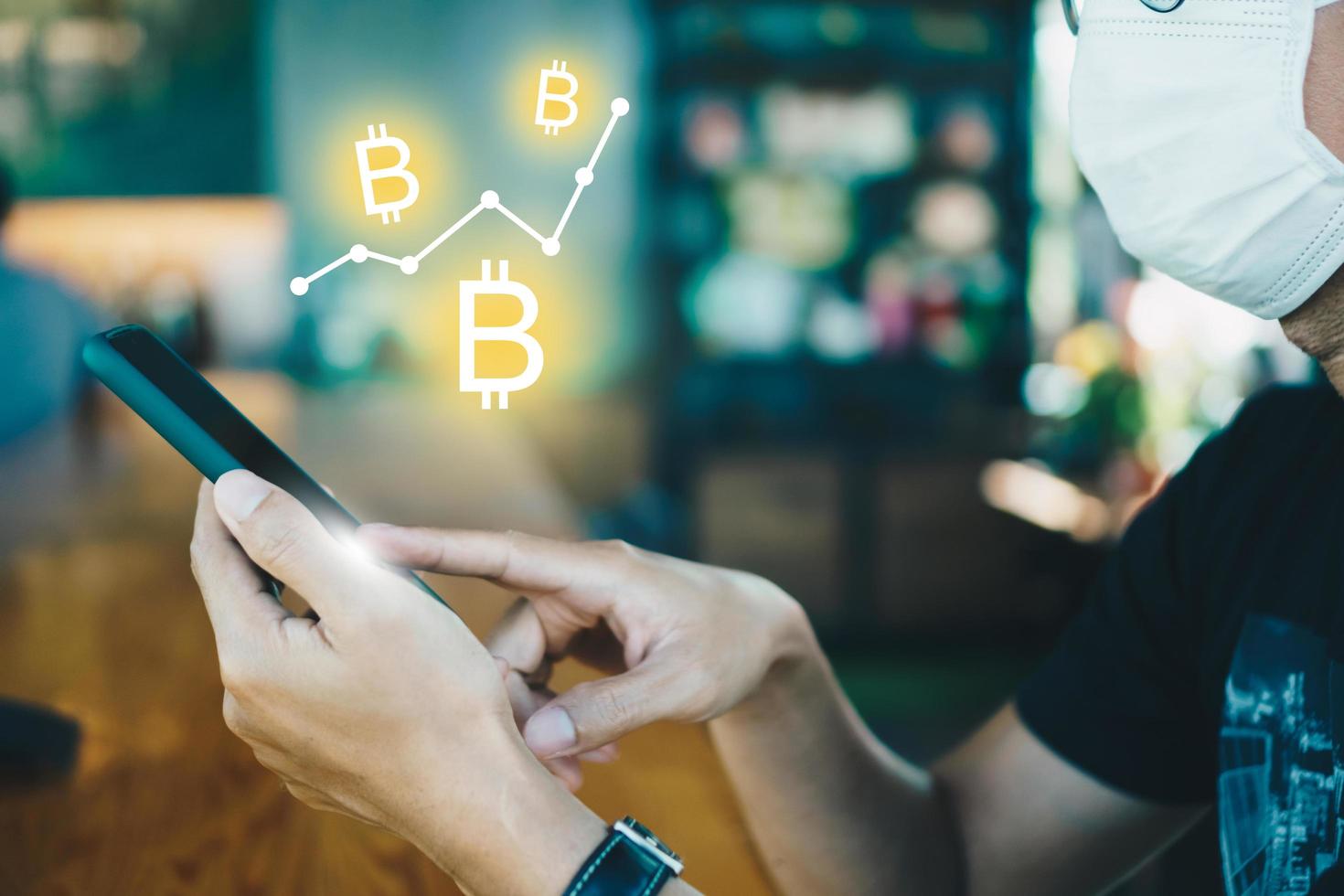 Person using smartphone with Bitcoin icons photo