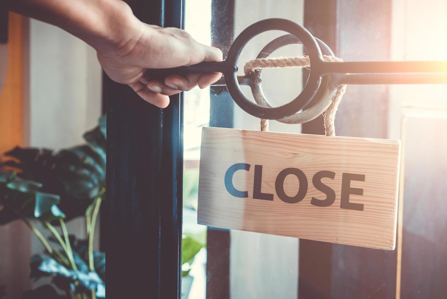 Closed sign hanging on door of business shop photo