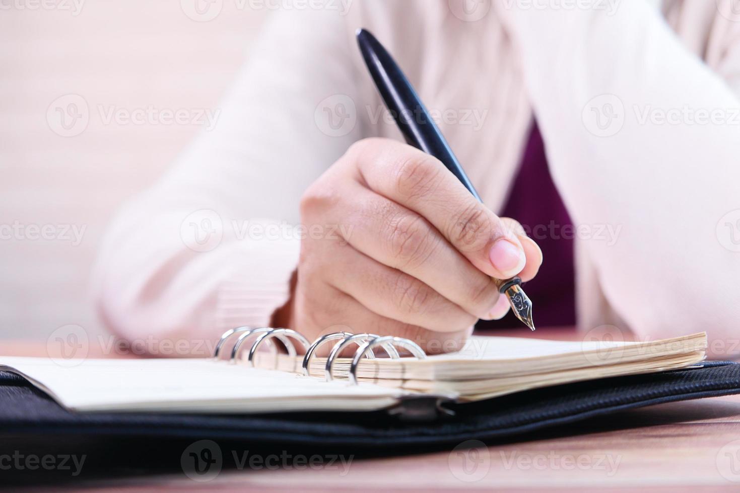 Woman writing in a journal photo