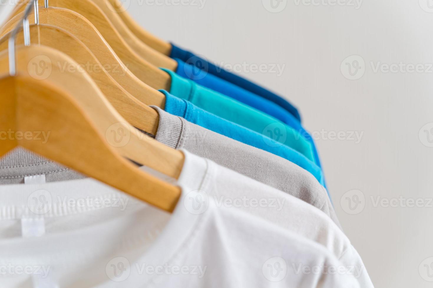 Cerca de camisetas en perchas, antecedentes de prendas de vestir foto