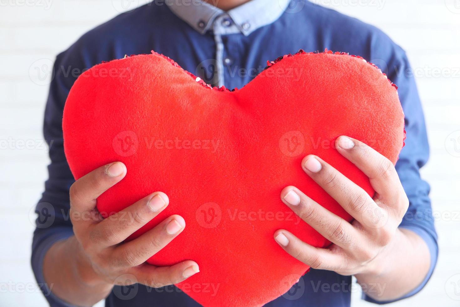 Hand holding red heart symbol on white background photo