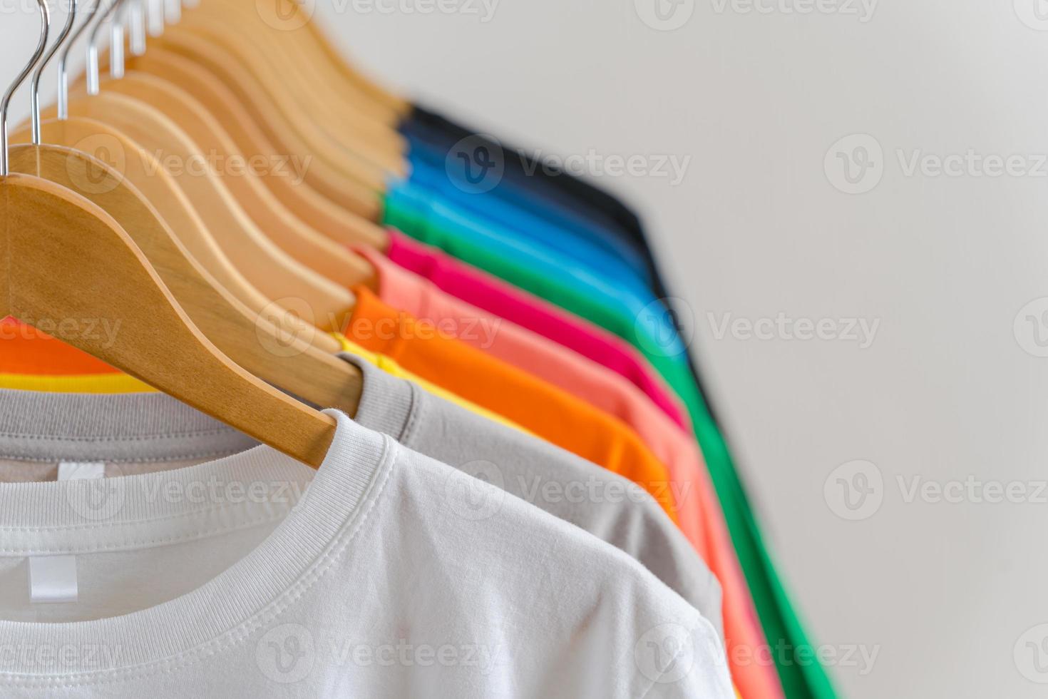 Cerca de camisetas en perchas, antecedentes de prendas de vestir foto