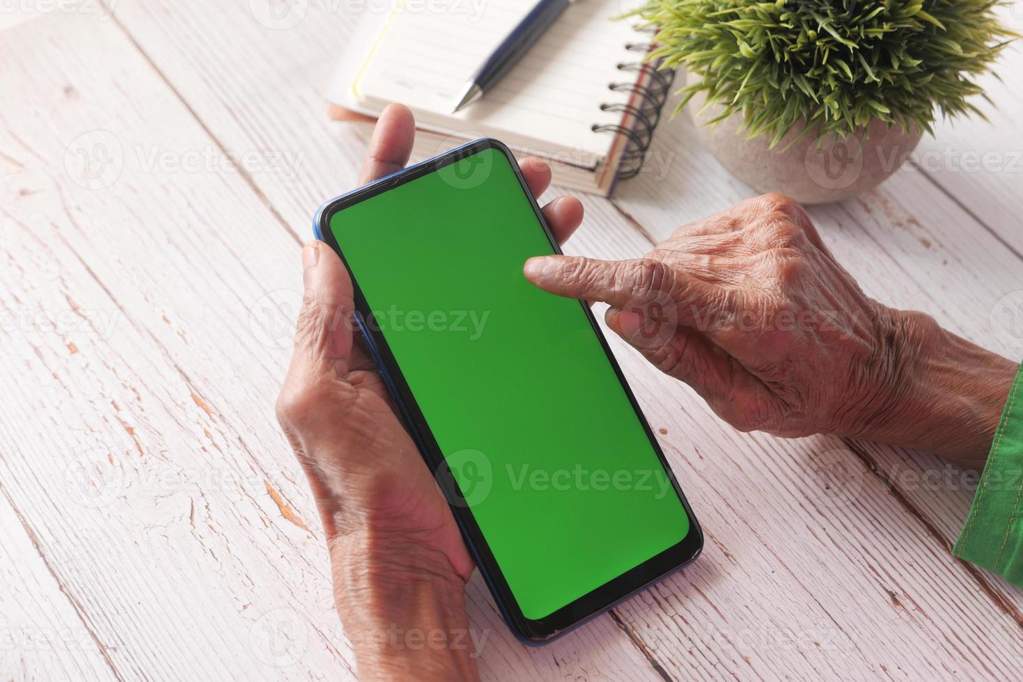 Person using smart phone with green screen photo