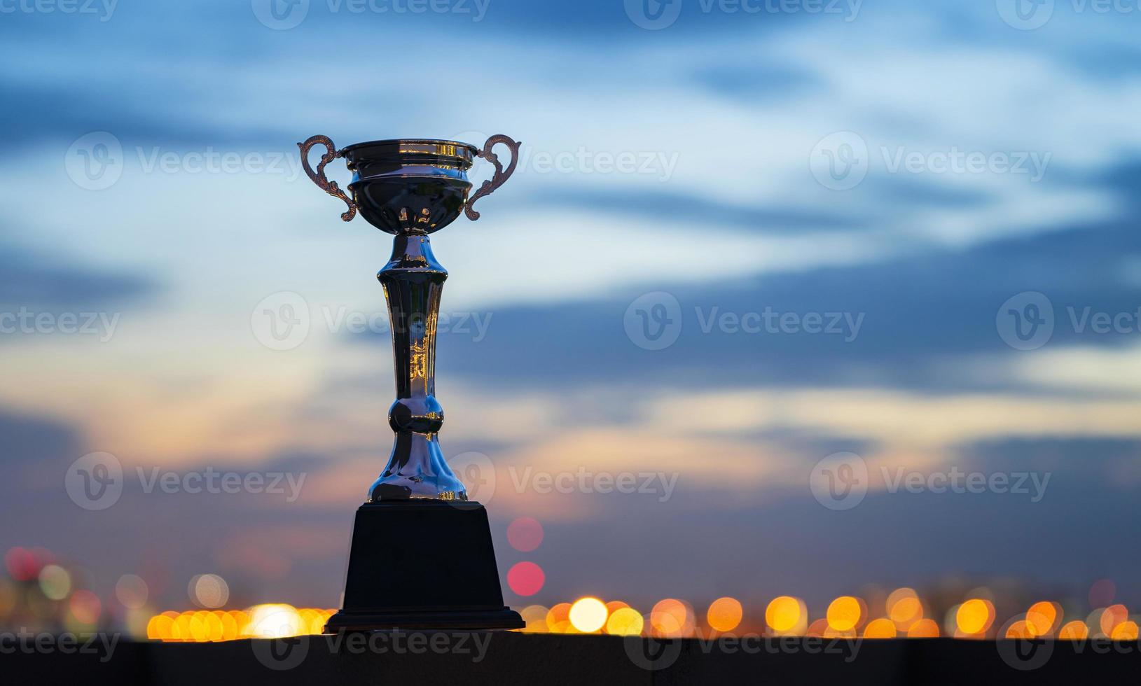 A trophy cup on against cloudy twilight sky background photo